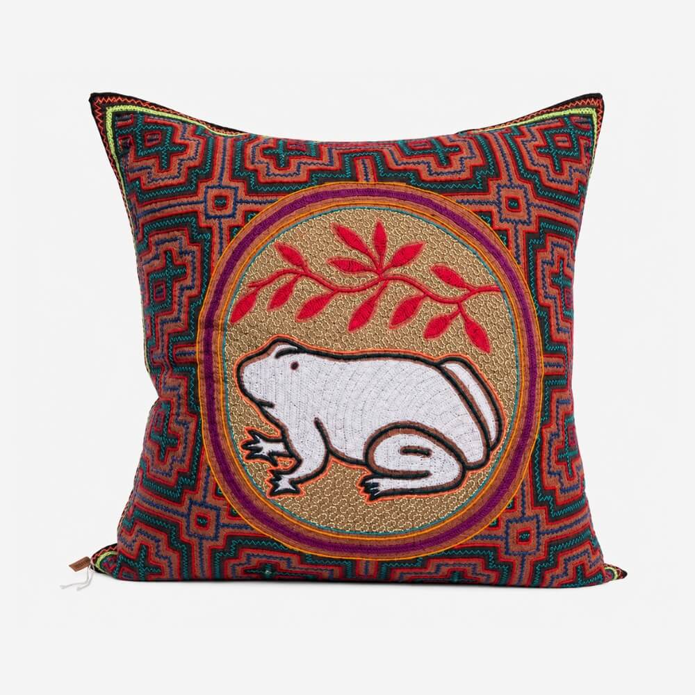 Hand-embroidered Shipibo cushion with a geometric border and a white frog motif, from the Lunaré Accessories collection.