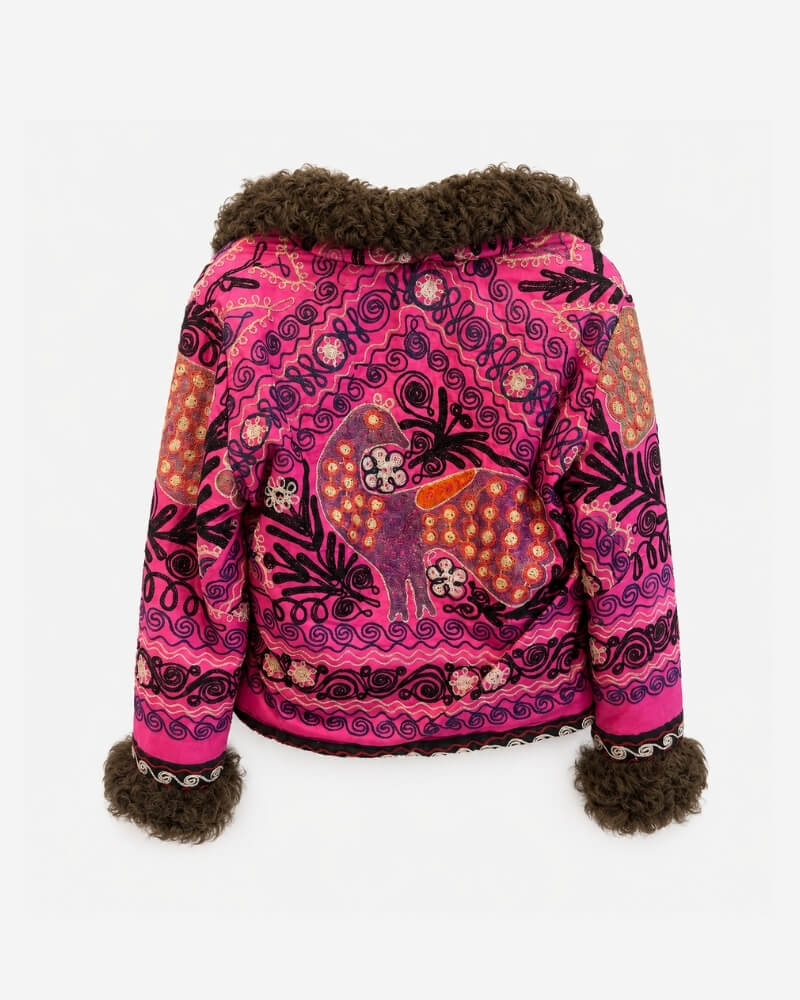 Coco Afghan Jacket No. 4, back view, in hot pink and black with a central embroidered deer motif, geometric swirl patterns, and a dark brown curly shearling collar and cuffs.