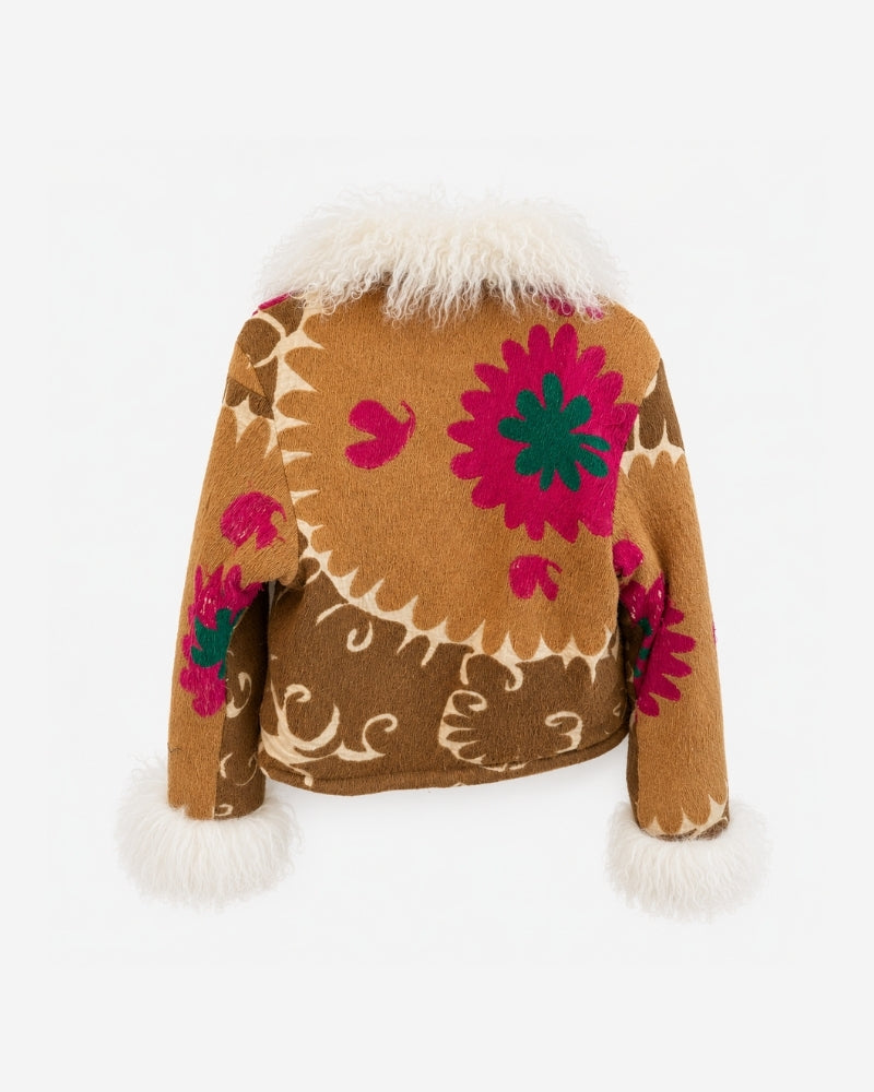 Coco Afghan Jacket No. 5 (M/L), back view, in tan with large magenta and green flower medallion embroidery, a cream vine border, and a cream shearling collar and cuffs.