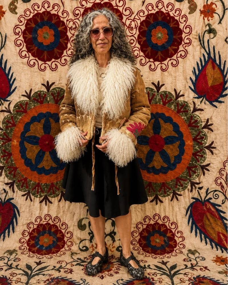 The Afghan Coat Martina No. 10 by Lunaré – front view on model, tan coat with cream shaggy shearling collar and cuffs.