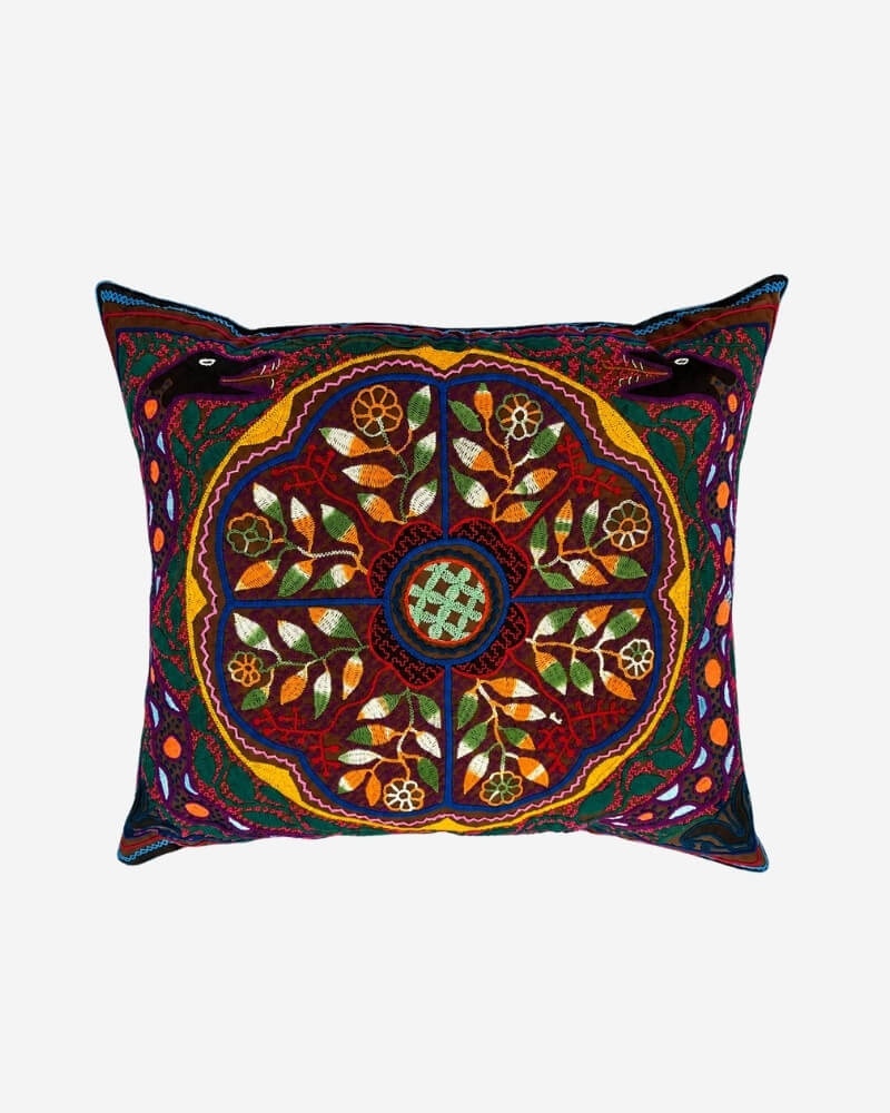 Hand-Embroidered Shipibo Cushion No. 4 with an Ícaro-inspired floral mandala pattern and bird motifs in the corners.