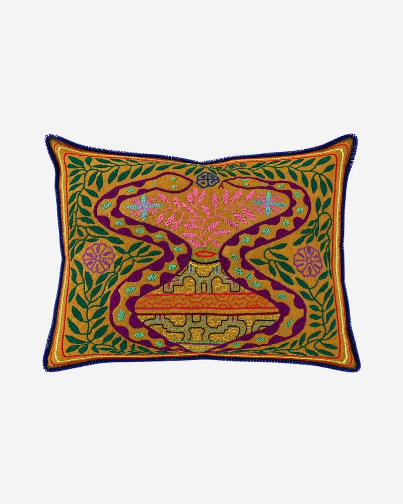 Hand-Embroidered Shipibo Cushion No. 13 in mustard, with an abstract hourglass-shaped pattern in maroon, pink floral embroidery and a green leaf vine border.