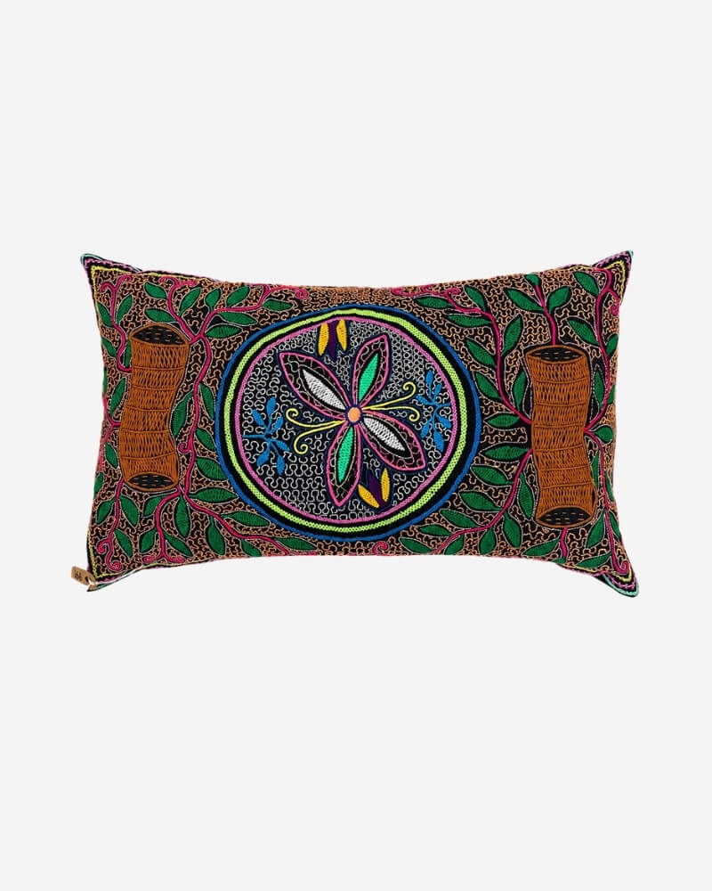 Hand-Embroidered Shipibo Cushion No. 18 in rust, with a central flower medallion pattern and embroidered tree branch motifs on each side.
