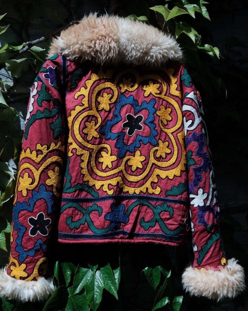 The Afghan Coat Coco No. 3 by Lunaré – back view outdoors, burgundy and green paisley patterned coat with cream shaggy shearling collar and cuffs.