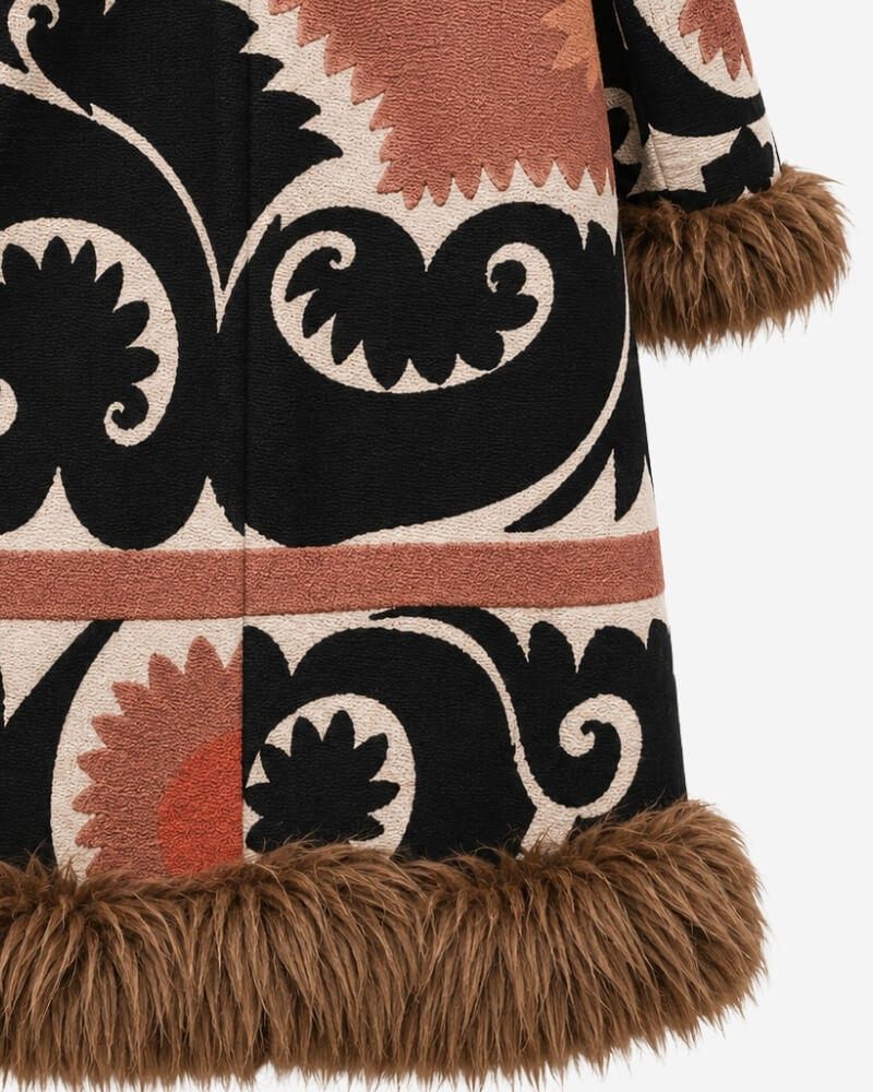 The Afghan Coat Ragna No. 3 by Lunaré – close-up detail of the hand-embroidered rust, black and cream pattern and camel-toned shaggy shearling cuff and hem trim.