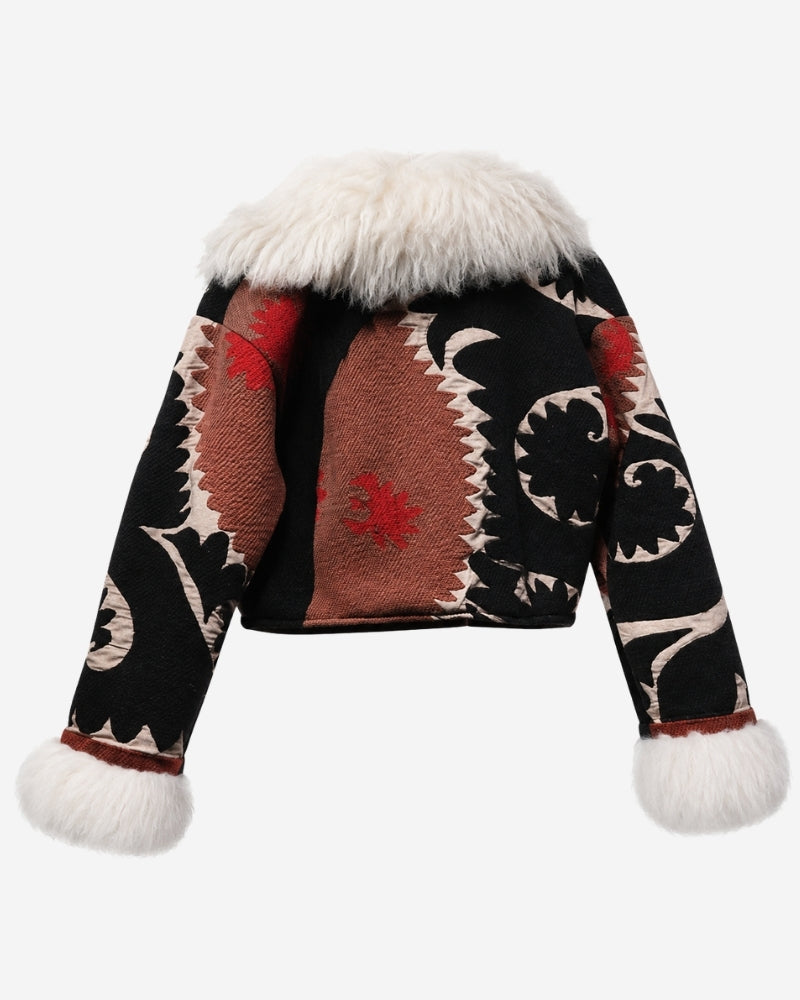 The Afghan Coat Coco No. 4 by Lunaré – back view with a rust-toned center panel and red floral accents flanked by black and ivory swirl leaf motifs, cream shaggy shearling collar and cuffs.