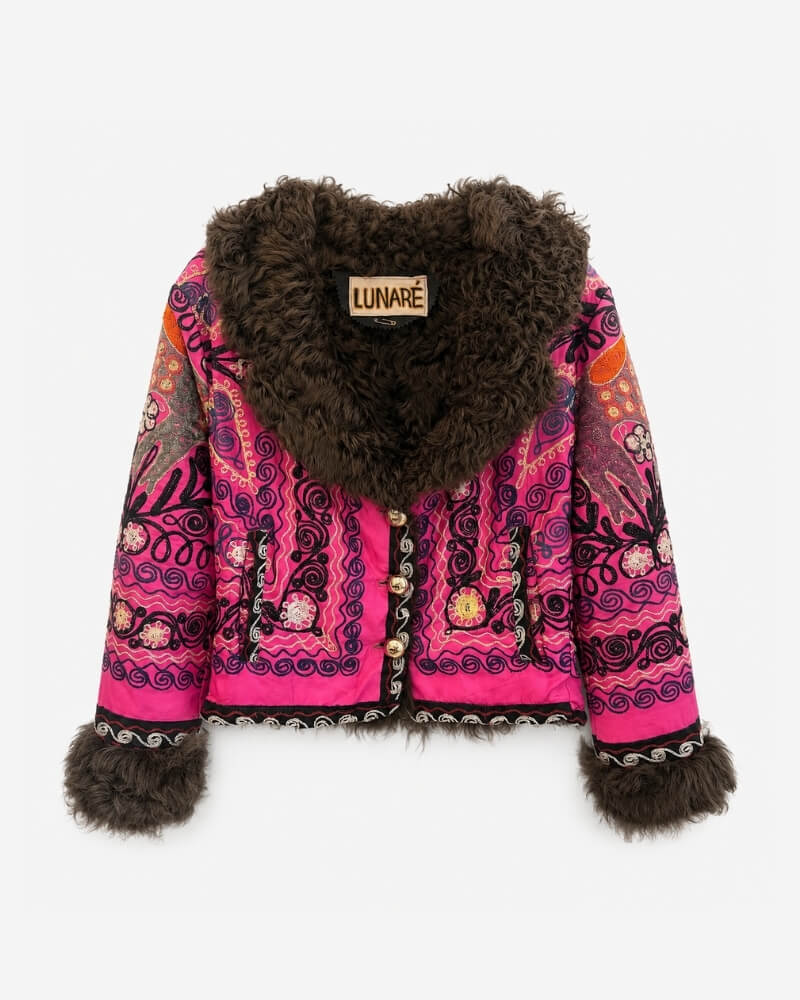 Coco Afghan Jacket No. 4, front view, in hot pink and black with a paisley and floral embroidery pattern in orange accents, gold button closure, and a dark brown curly shearling collar and cuffs.
