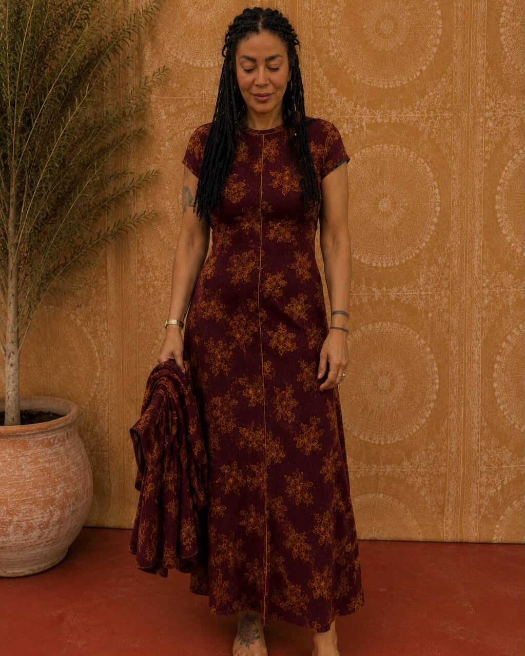 Woman wearing the Luna Dress in burgundy floral print, front view showing the full flowing skirt.