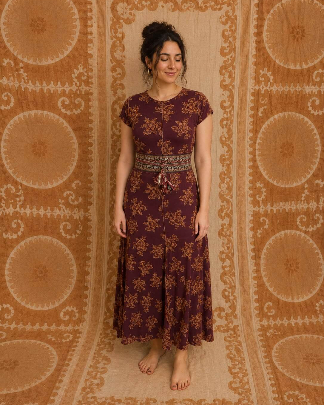 Luna Dress by Lunaré – lifestyle shot on model, burgundy maxi dress with gold floral print and short sleeves.