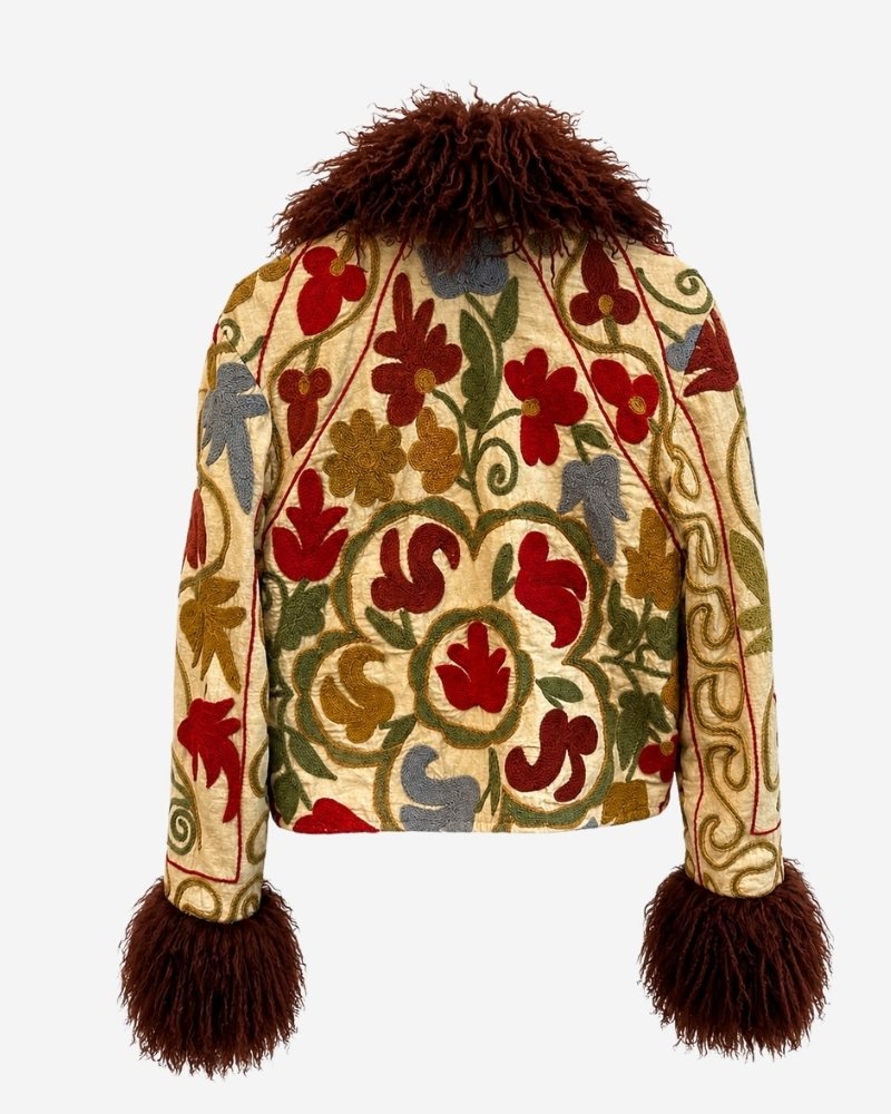 The Afghan Coat Martina No. 12 by Lunaré – back view flat lay, cream coat with hand-embroidered floral vine pattern in rust, olive and blue, brown shaggy shearling collar and cuffs.