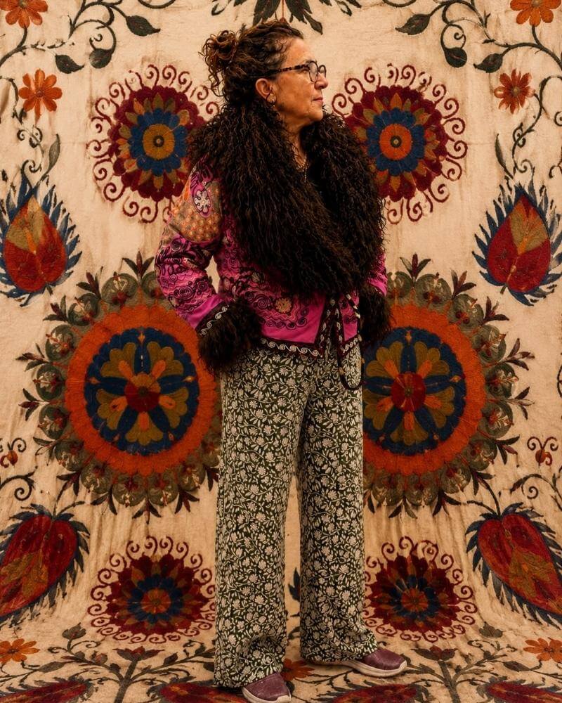 The Afghan Coat Martina No. 2 by Lunaré – back view on model, pink and multicolor embroidered coat with dark brown shaggy shearling collar and cuffs.