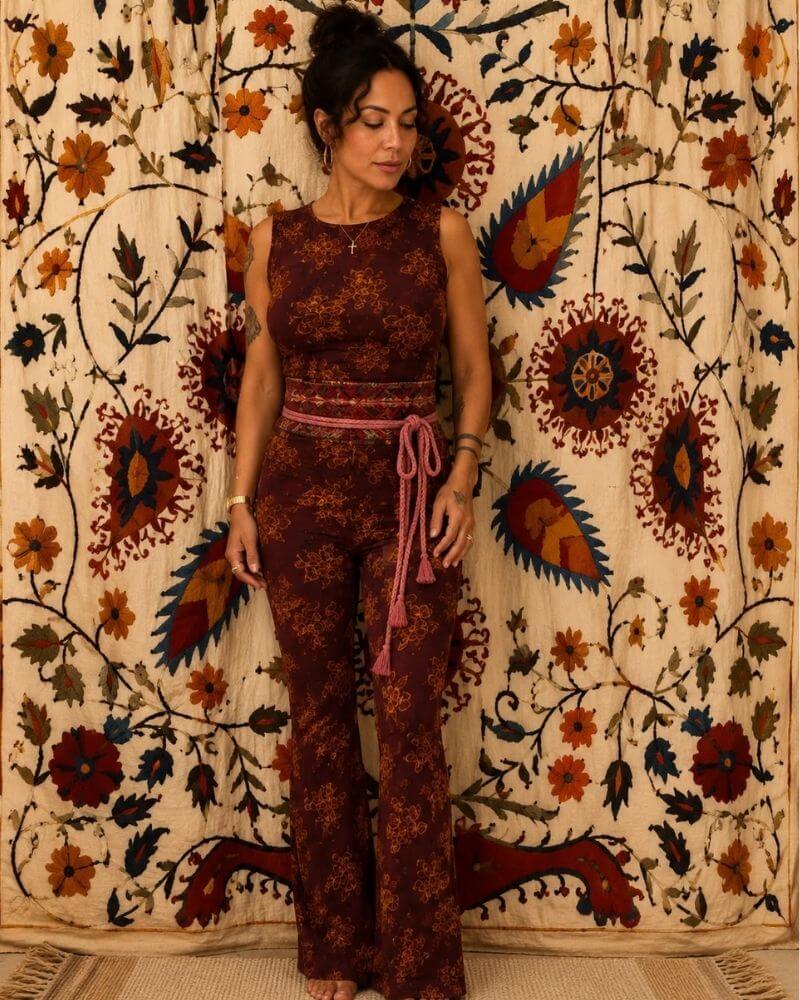 Nube Set 2 by Lunaré – lifestyle shot on model, rust and cream floral print sleeveless top and flared pants with pink tie belt.