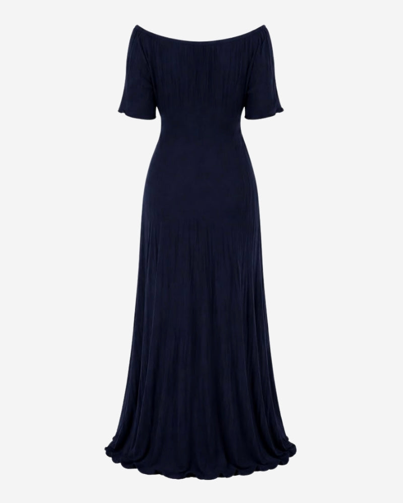 Back view of the Rose Dress in navy ribbed knit, showing adjustable back lacing and the fluted hem.