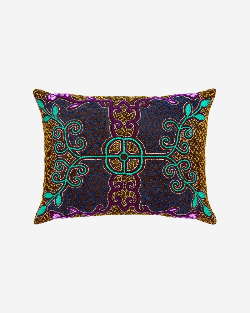 Hand-Embroidered Shipibo Cushion No. 12 in brown, with a symmetrical green scroll and vine pattern forming a central cross, accented with magenta and small pink flowers.
