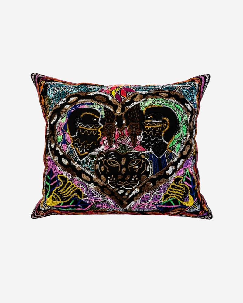 Hand-Embroidered Shipibo Cushion No. 1 in black with colorful jungle-inspired embroidery, featuring symmetrical face motifs and bird details.
