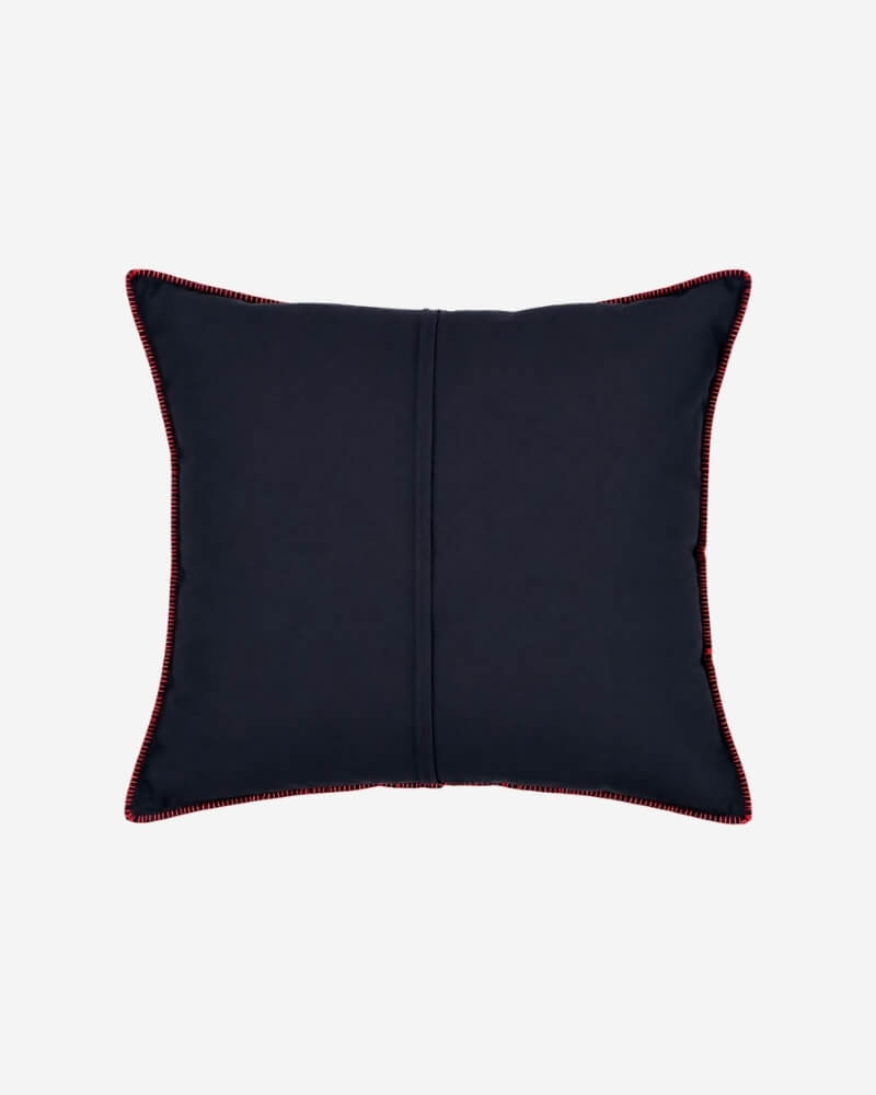 Hand-Embroidered Shipibo Cushion No. 15 by Lunaré – back view, solid navy cotton cover with red contrast piping along the edges.