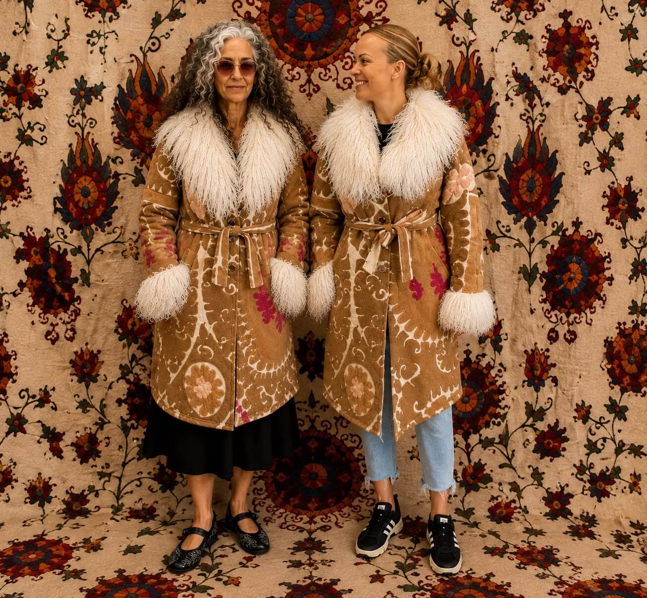 The Afghan Coat Silje by Lunaré – lifestyle shot on two models, tan embroidered coat with cream shaggy shearling collar and cuffs.