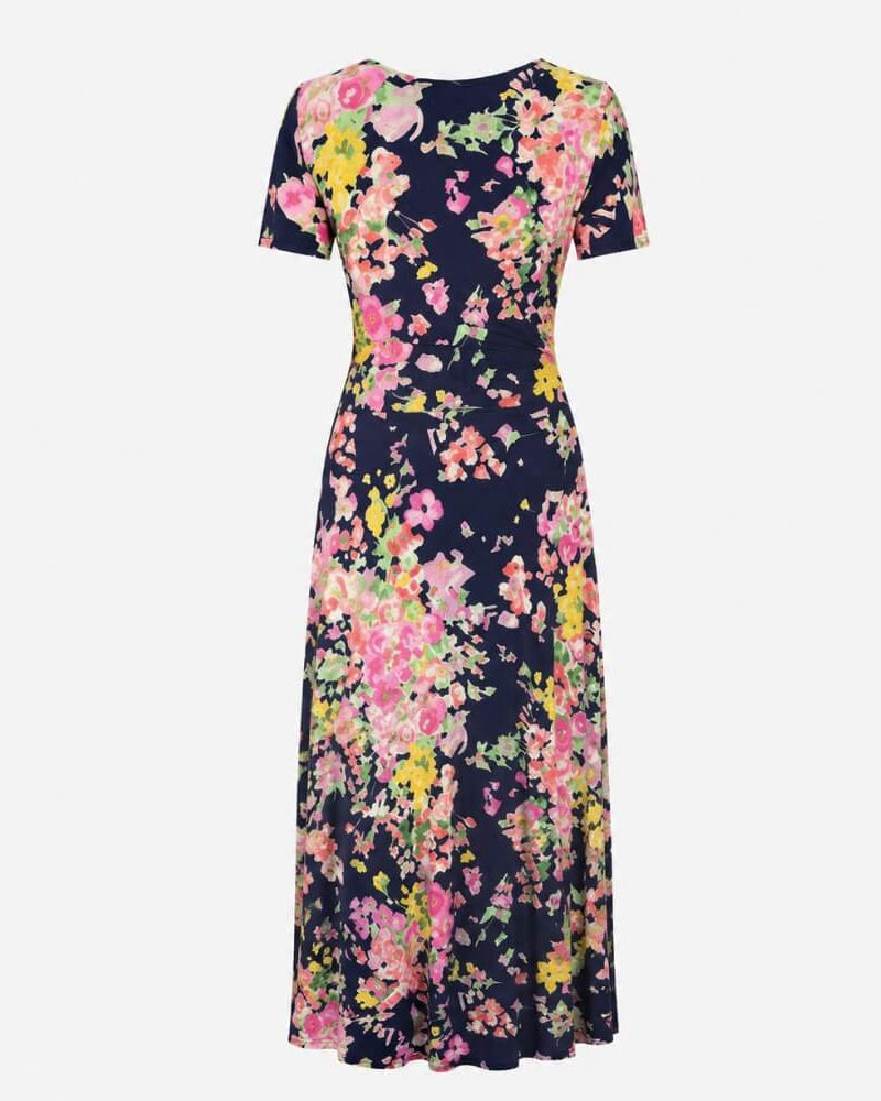 Back view of the Sine Dress in navy floral print, short sleeves and a floor-length silhouette.