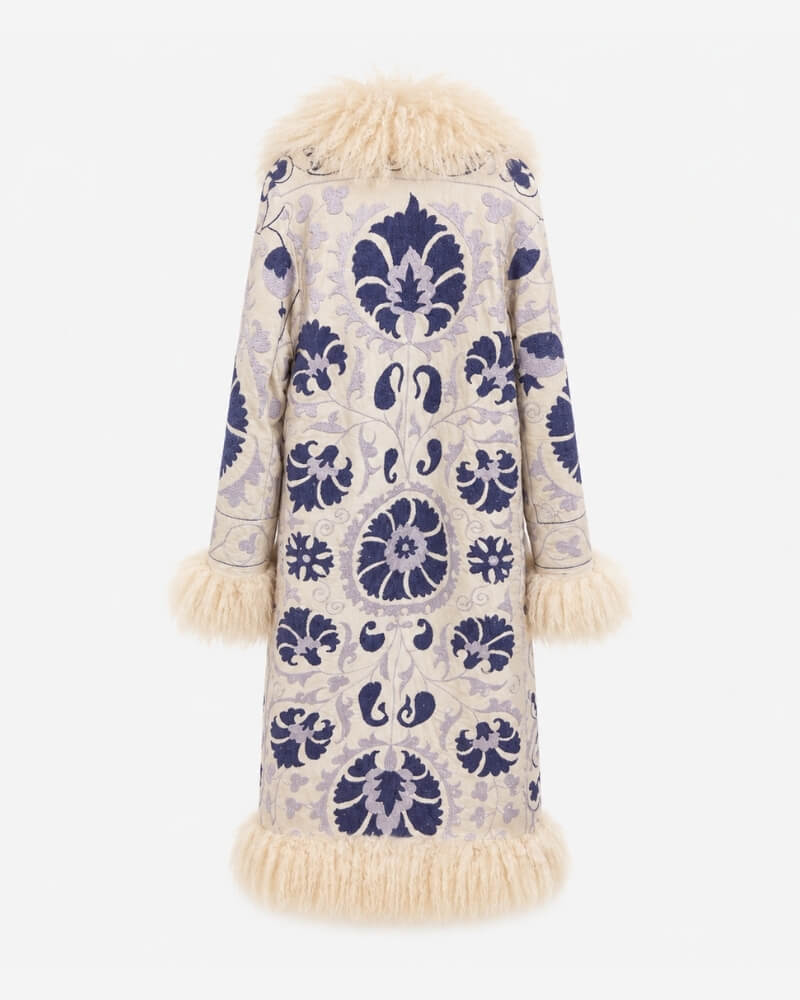 The Afghan Coat Ragna No. 1 by Lunaré – back view showing dense navy blue hand-embroidered medallion pattern on cream fabric with cream lambskin trim at collar, cuffs and hem.