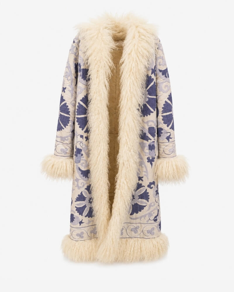 The Afghan Coat Ragna No. 1 by Lunaré – front view, cream mid-calf coat with hand-embroidered blue floral medallions and lambskin trim.